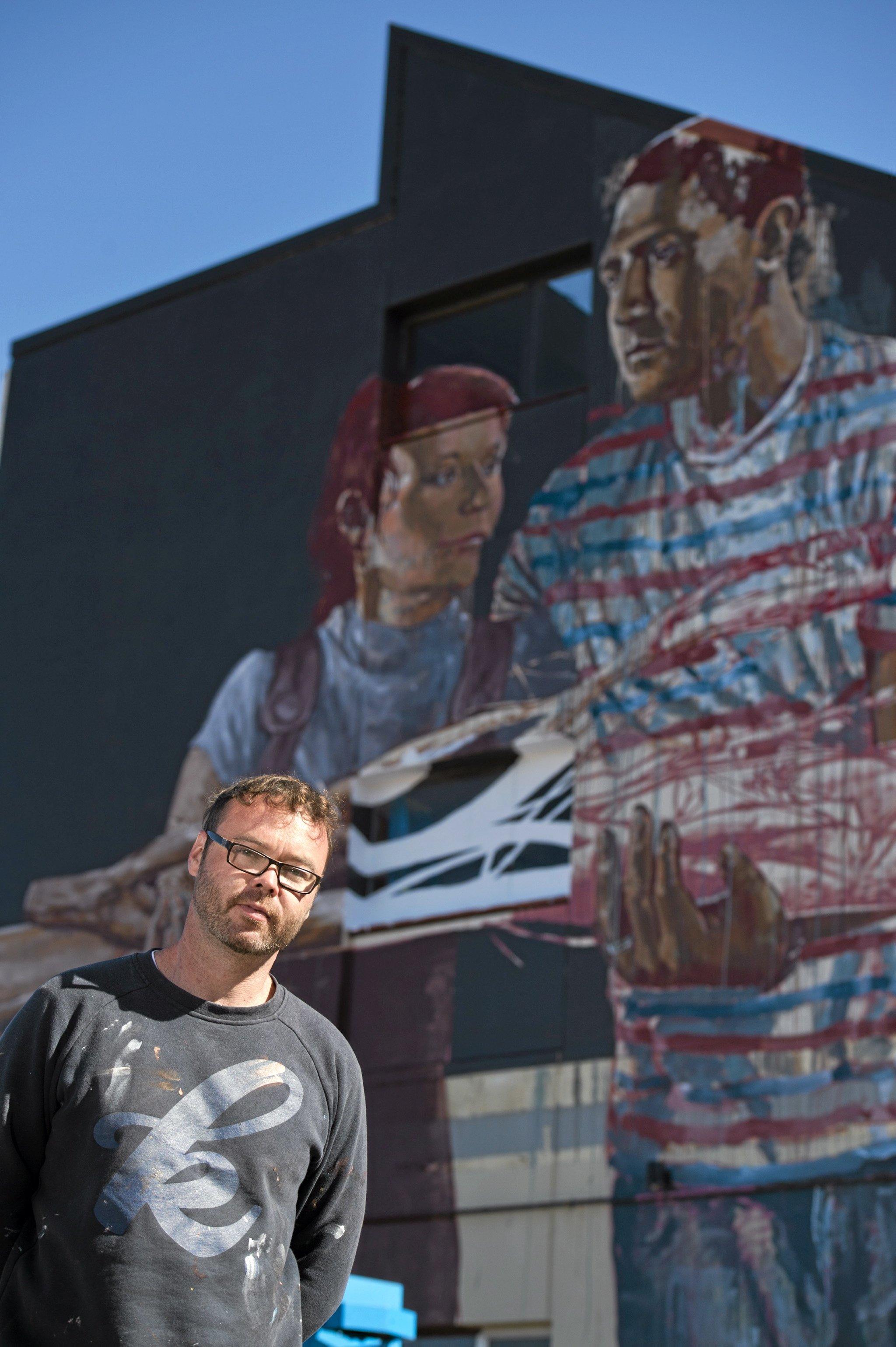 Fintan Magee paints on the SES building wall in Hume St car park for First Coat, Monday, May 30, 2016. Picture: Kevin Farmer