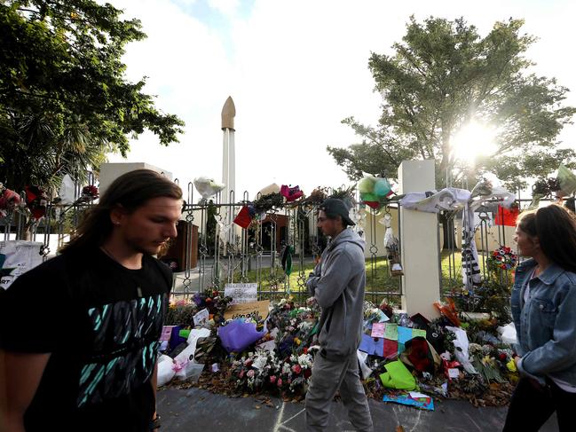 People walk past flowers displayed in memory of the twin mosque massacre victims outside the Al Noor mosque in Christchurch. Picture: AFP