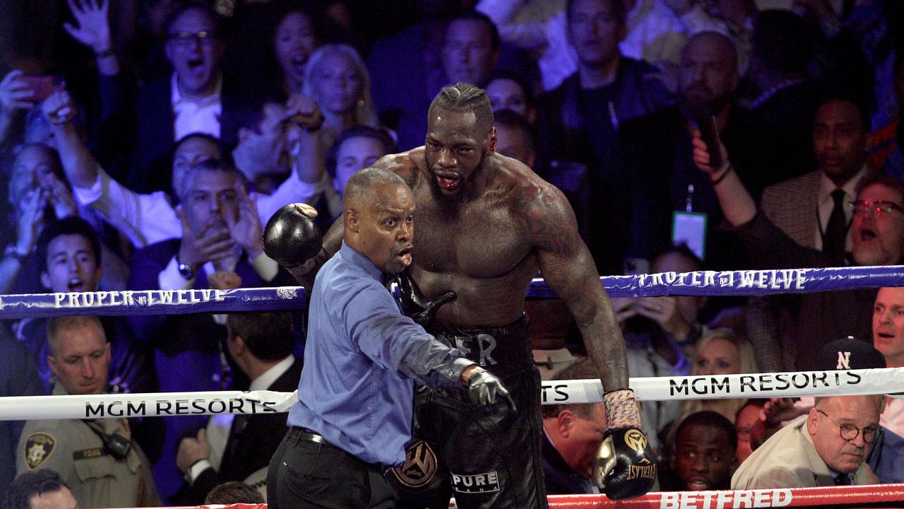 Referee Kenny Bayless directs Deontay Wilder to his corner.