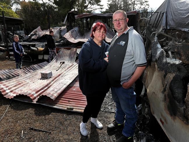 Darren and Belinda Bayliss and their children Tarleigha, 17, and Laithen, 12, look over the ruins of their Woodford home. Picture: Toby Zerna