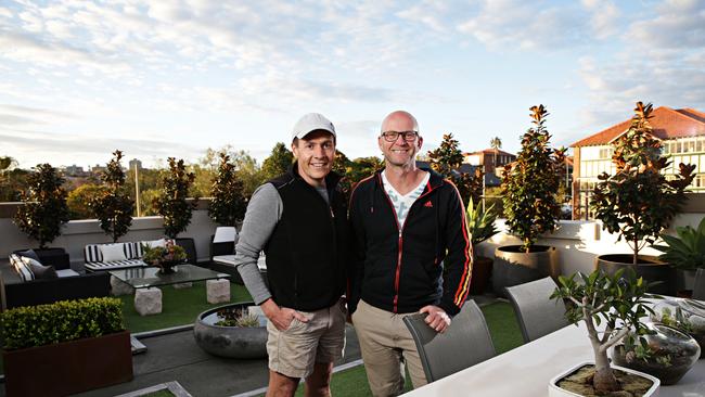 Andrew and Pete in front of the upstairs garden after they styled the space differently by adding plants, furniture and a water feature.