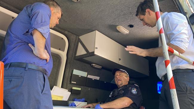 Officer in Charge of the Bundaberg Road Policing Unit Sergeant Marty Arnold shows Police Minister Mark Ryan and Bundaberg MP Tom Smith inside the roadside drug and alcohol testing van.