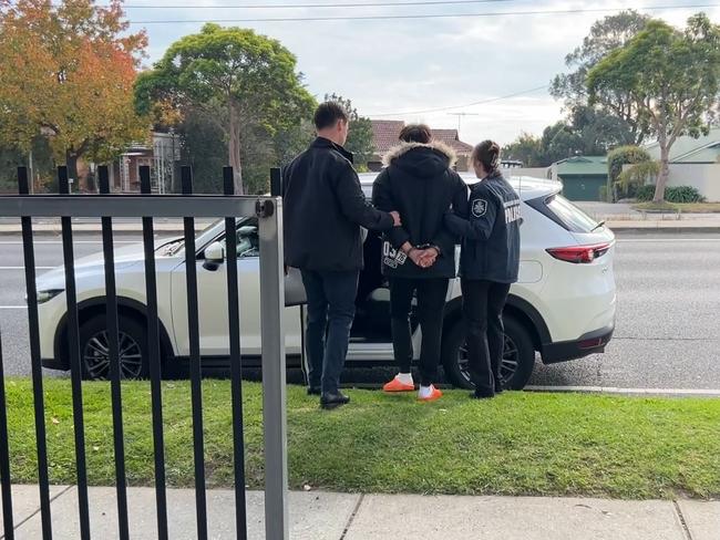 Sin Keong Choong being led away by AFP investigators outside his Burwood home. Picture: AFP