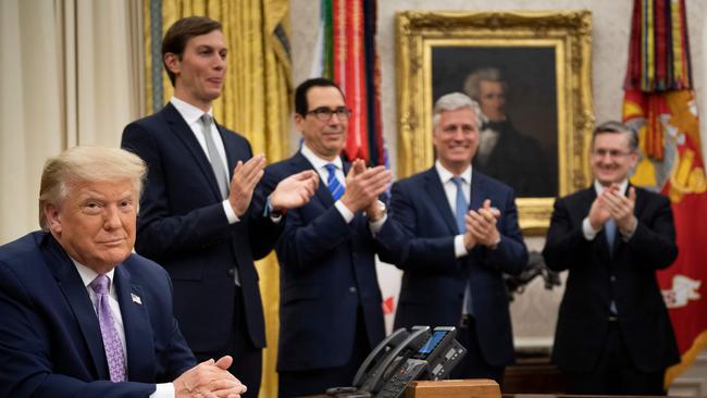 (L-R, rear) Senior Advisor Jared Kushner, US Secretary of the Treasury Steven Mnuchin and National Security Advisor Robert O'Brien clap for US President Donald Trump (L) after he announced an agreement between UAE and Israel.