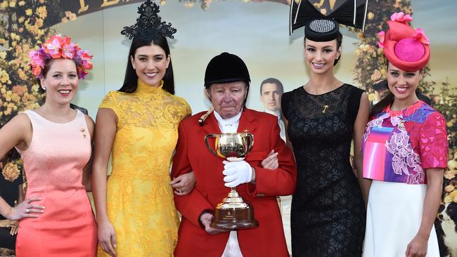 Former Flemington racecourse clerk of the course John Patterson (centre) poses for a photo with the Melbourne Cup and (L-R) Renata Koponski, Rebecca Stoneman, Alex Hecker and Brodie Worell. AAP Image/Julian Smith.