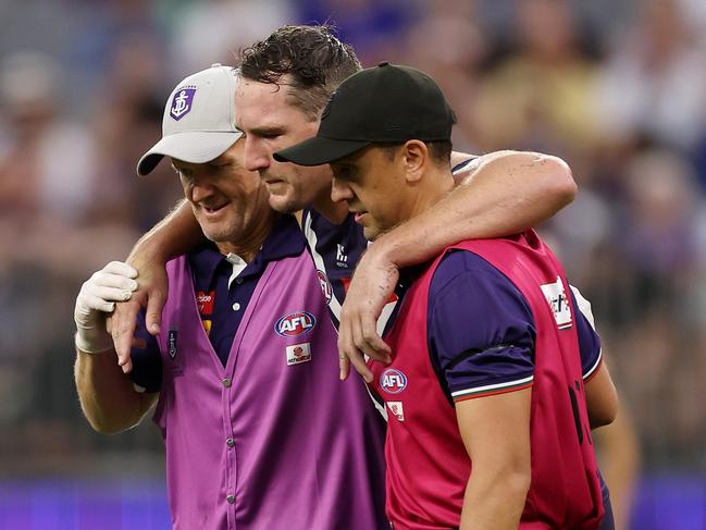 Brennan Cox is helped off with a serious hamstring injury. Picture: Will Russell/AFL Photos via Getty Images