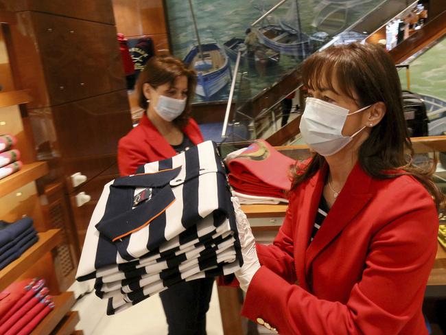 Women with protective masks are preparing to open a store in Vienna, Austria. Smaller Austrian shops may now reopen with special protective measures. Picture: AP