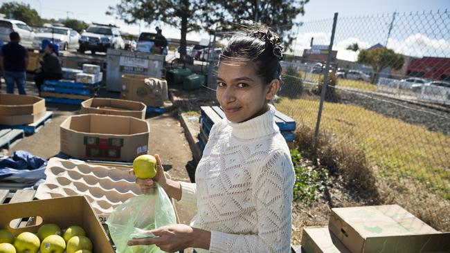 USQ student Harpinder Kaur selects some apples donated for isolated international students.. Picture: Kevin Farmer