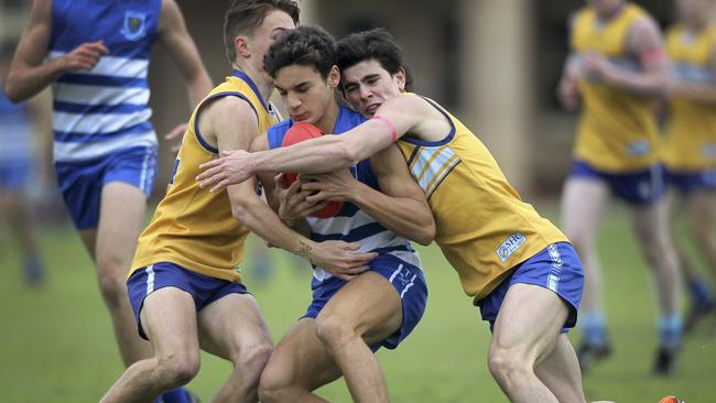 Sacred Hearts’ Max Harry (R) and Xavier Robins (L) tackle Saint Peter's player Ben Roberts. Picture: AAP//Dean Martin