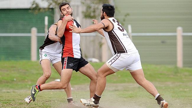 West Coburg's Tom Watterson tries to break clear of two Craigieburn opponents earlier this season. Photo: Angie Basdekis