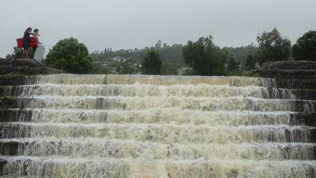 The floodwaters cascade from Flooded Gum Park at Pacific Pines. Picture: Glenn Hampson