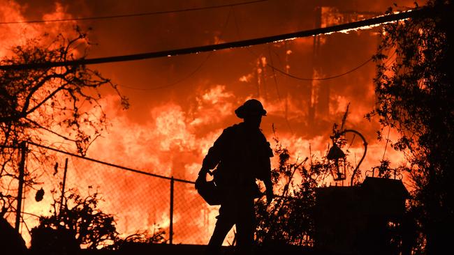 OVERWHELMED: A firefighter at a burning home during the Woolsey Fire in Malibu, California in November. Picture: AFP