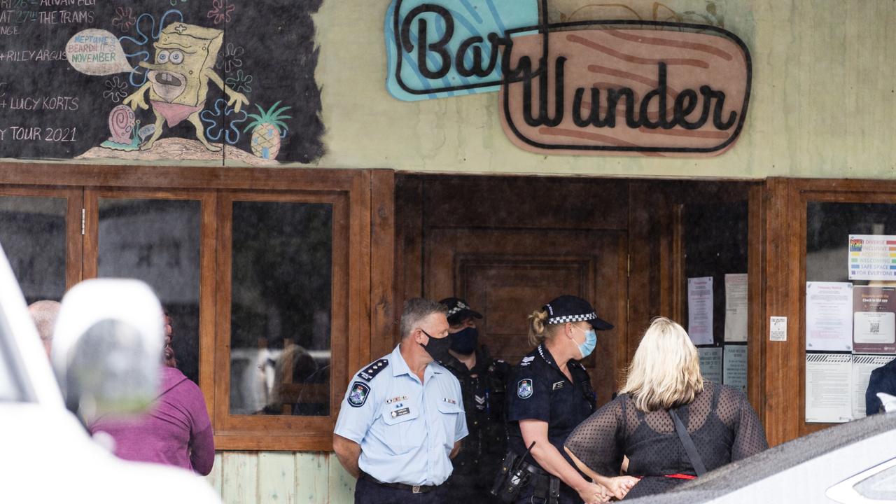 Police stand blocking the entrance to Bar Wunder as people gather on the footpath outside the Toowoomba bar shut down over failing to comply with public health orders, Friday, December 31, 2021. Picture: Kevin Farmer