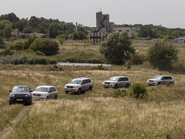 Vehicles transporting observers from the Organisation for Security and Co-operation in Europe drive through the main crash site of Malaysia Airlines flight MH17 in Grabovo, Ukraine. Picture: Rob Stothard/Getty Images