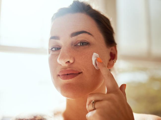 Shot of an attractive young woman applying moisturiser during her morning beauty routine