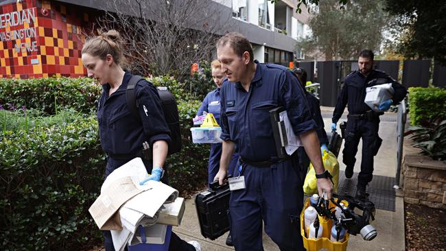 Forensic police leaving the apartment block where the three-year-old boy was found. Picture: Adam Yip