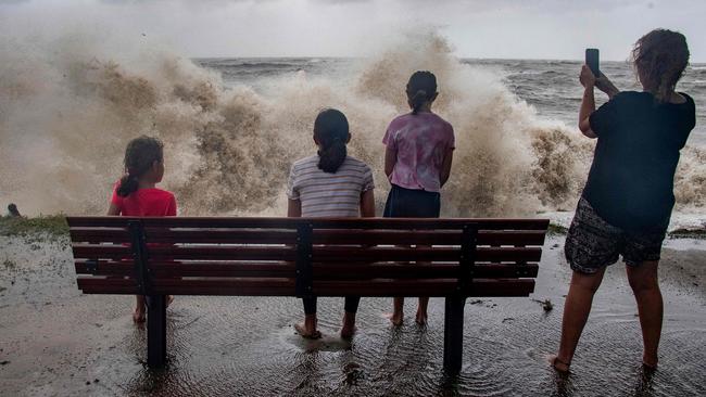 Children watch the storm roll in at Holloways Beach, north of Cairns. Picture: AFP