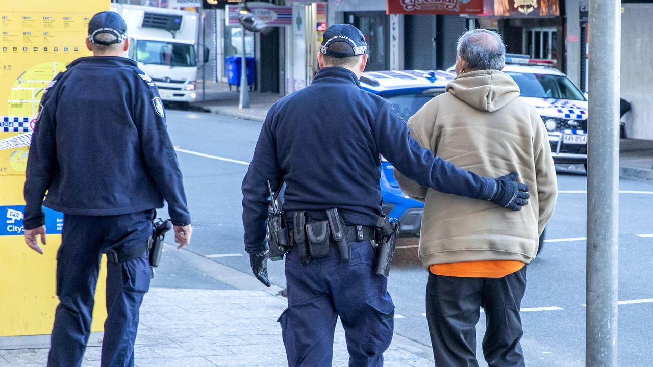 A man is moved away from the scene as police continue investigations. Picture: Richard Walker