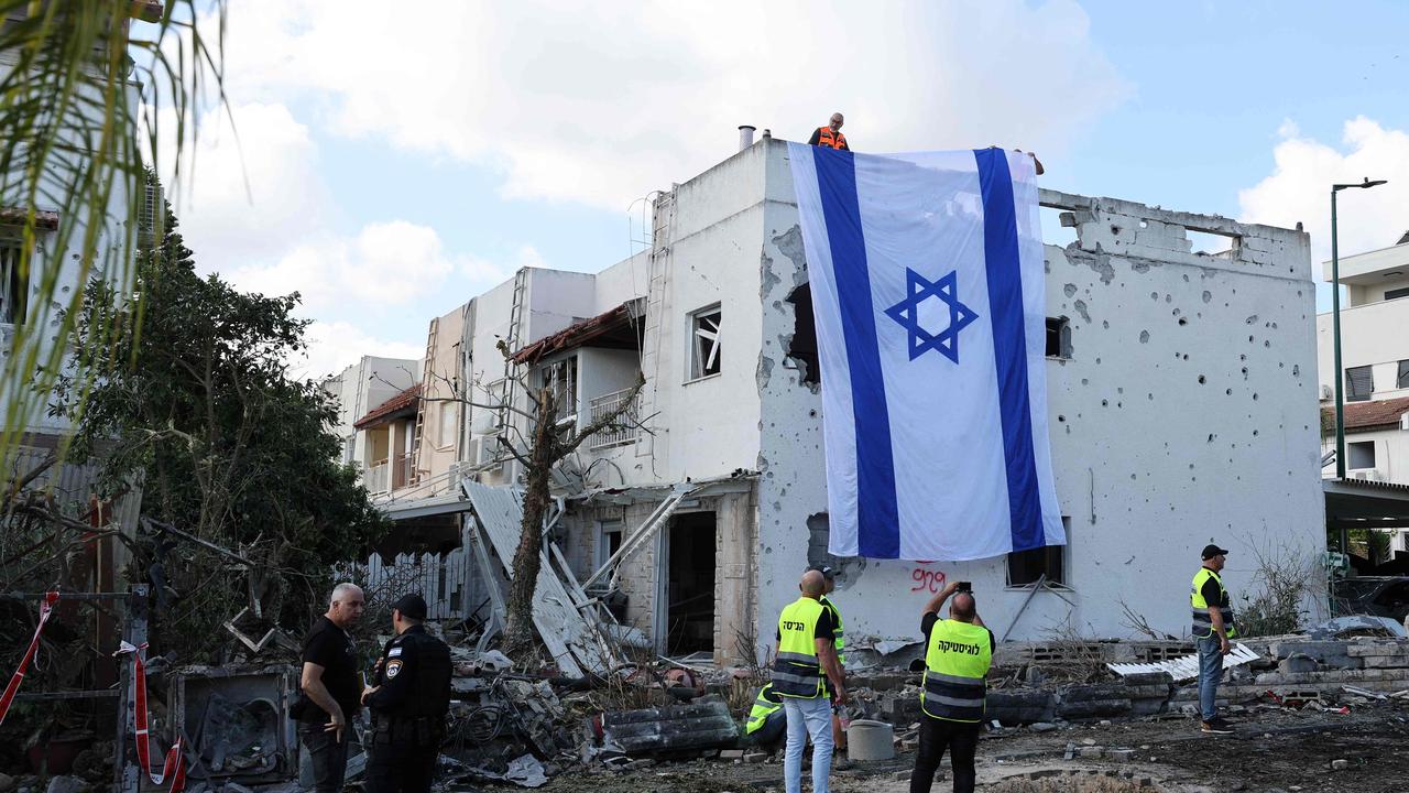 An Israeli flag deployed on the wall of a damaged building in Kiryat Bialik in the Haifa district. Picture: Jack Guez/AFP