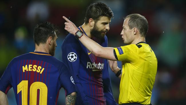 Barcelona's Gerard Pique, center, protests after getting a red card from referee William Collum
