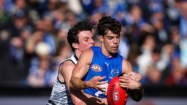 GEELONG, AUSTRALIA - JULY 09: Jy Simpkin of the Kangaroos is tackled by Max Holmes of the Cats during the 2023 AFL Round 17 match between the Geelong Cats and the North Melbourne Kangaroos at GMHBA Stadium on July 9, 2023 in Geelong, Australia. (Photo by Dylan Burns/AFL Photos via Getty Images)