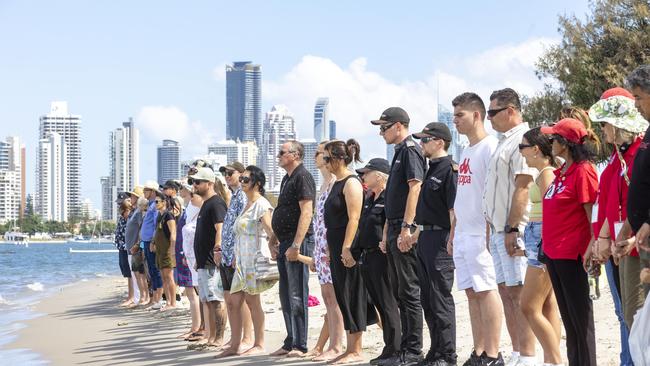 Mourners hold hands at Broadwater Parklands to pay their respect to those killed in the horror Sea World helicopter crash. A public vigil was held to honour the victims of the accident. NewsWire / Sarah Marshall