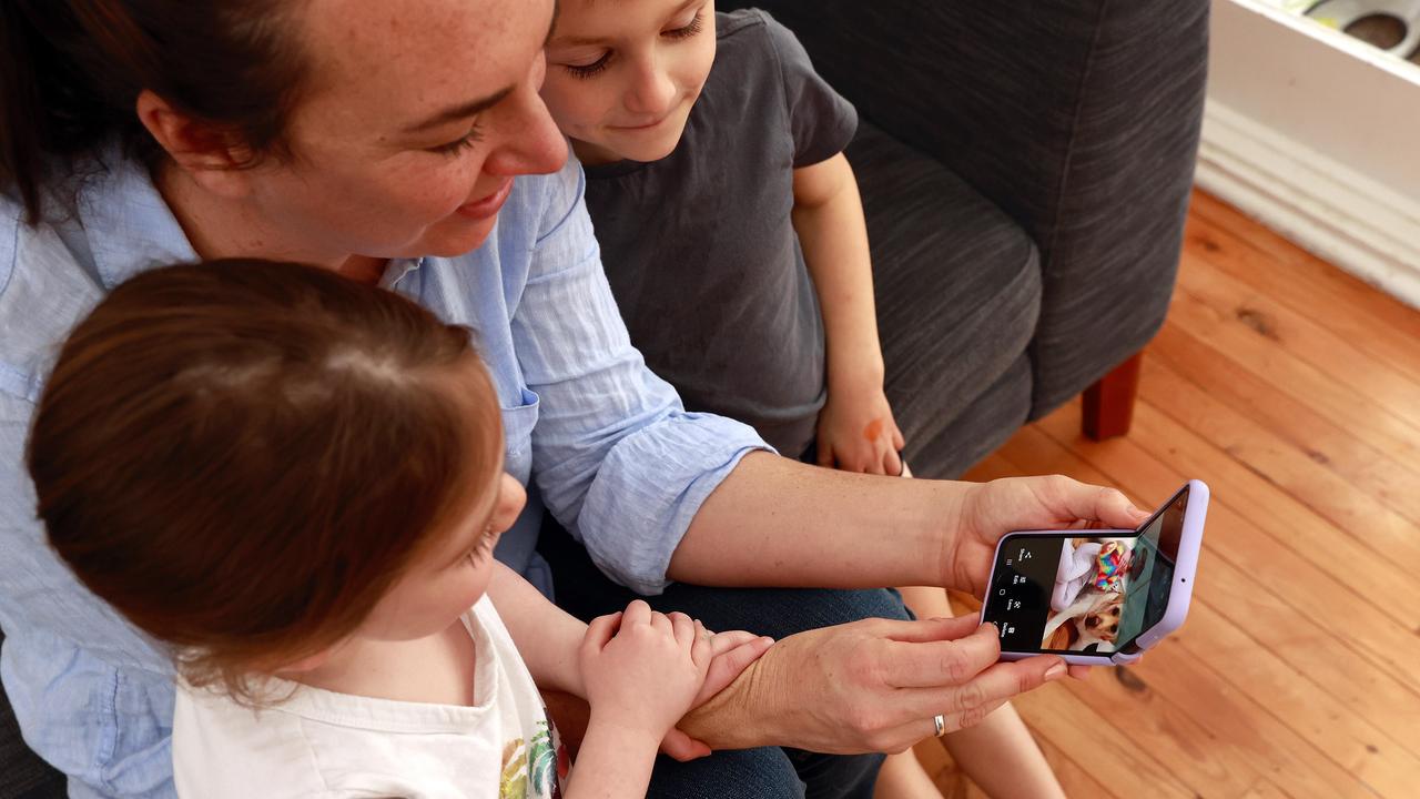 Rebecca Tesoriero with her kids Lydia 3 and Vincent 5, and her folding phone. Picture: Tim Hunter.