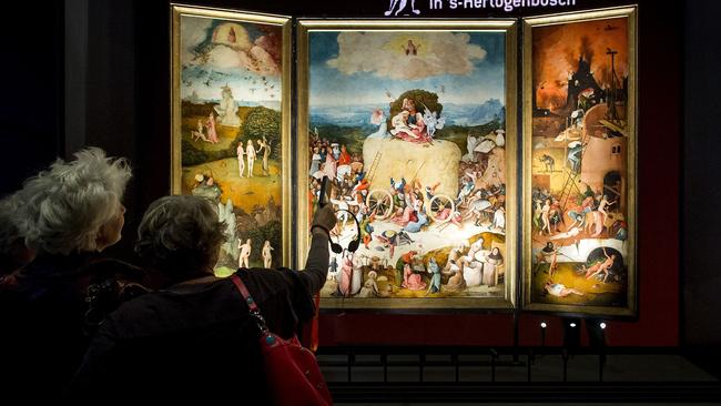 Visitors look at the painting 'De Hooiwagen' (The Haywain Triptych) painted by Dutch Renaissance artist Jheronimus Bosch (or Hieronymus, or Jeroen Bosch) during a press preview of the exhibition "Hieronymus Bosch - Visions of a Genius" at the Noordbrabants Museum in Den Bosch on February 11, 2016. The exhibition will run from February 13 till May 8, 2016. / AFP / ANP / Koen van Weel