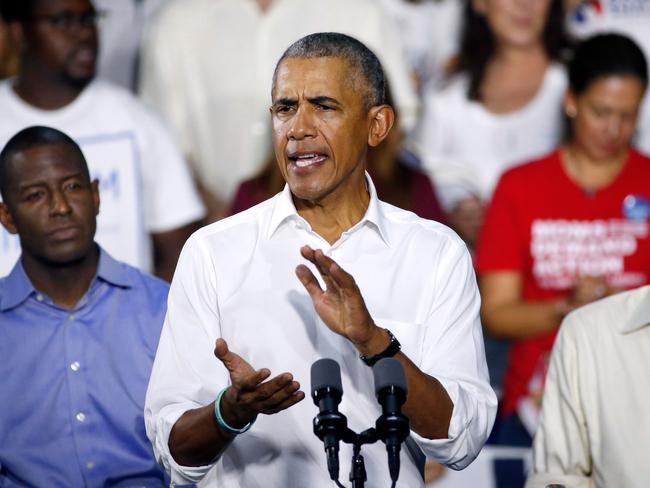 TOPSHOT - Florida Democratic gubernatorial nominee Andrew Gillum (L), and Senator Bill Nelson (D-FL) (R) listen to former President Barack Obama as he addresses the media and supporters as they stump for votes at a rally in Miami, Florida November 2, 2018. (Photo by RHONA WISE / AFP)