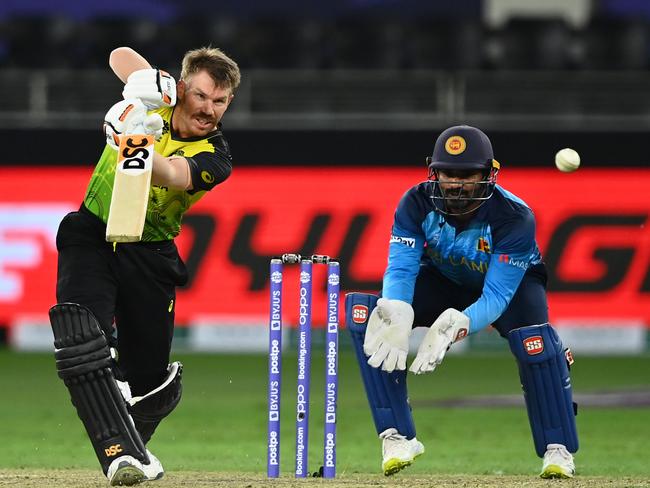 DUBAI, UNITED ARAB EMIRATES - OCTOBER 28: David Warner of Australia plays a shot as Kusal Perera of Sri Lanka looks on during on the ICC Men's T20 World Cup match between Australia and Sri Lanka at Dubai International Stadium on October 28, 2021 in Dubai, United Arab Emirates. (Photo by Alex Davidson/Getty Images)