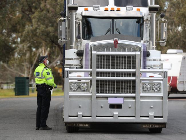 A police officer speaks to a truck driver in July at Bordertown. Picture: Tait Schmaal