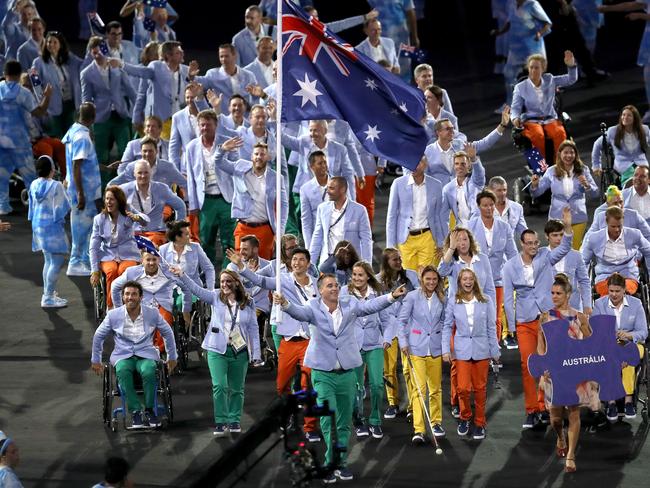 Flag bearer Bradley Ness leads the Australia team out in to the stadium.