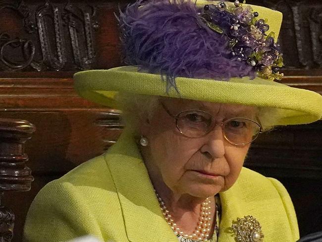 (FILES) In this file photo taken on May 19, 2018 Britain's Queen Elizabeth II looks on during the wedding ceremony of Britain's Prince Harry, Duke of Sussex and US actress Meghan Markle in St George's Chapel, Windsor Castle, in Windsor, west of London. - Britain's Prince Harry and his wife Meghan will give up their titles and stop receiving public funds following their decision to give up front-line royal duties, Buckingham Palace said on January 18, 2020. "The Sussexes will not use their HRH titles as they are no longer working members of the Royal Family," the Palace said, adding that the couple have agreed to repay some past expenses. (Photo by Jonathan Brady / POOL / AFP)