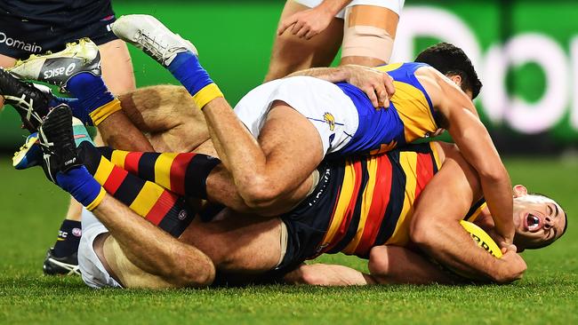 Thomas Cole of the Eagles tackles Taylor Walker of the Adelaide Crows.