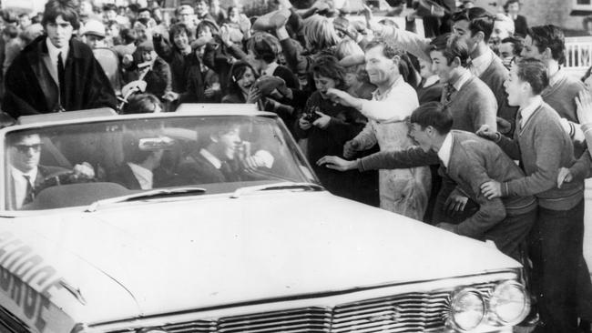 15th June 1964: Workmen and schoolchildren mob the car carrying British pop sensation The Beatles from Adelaide airport during their Australian tour. (Photo by Keystone/Getty Images)