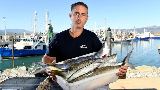 Lucas Dansie, owner Northshore Seafood Co. with two barramundi and two Queenfish caught in the bay behind him. Picture: Shae Beplate.