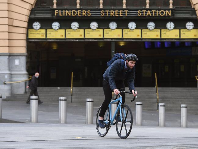 A cyclist passes a near-deserted Flinder Street Station during the morning rush hour in Melbourne. Picture: AFP