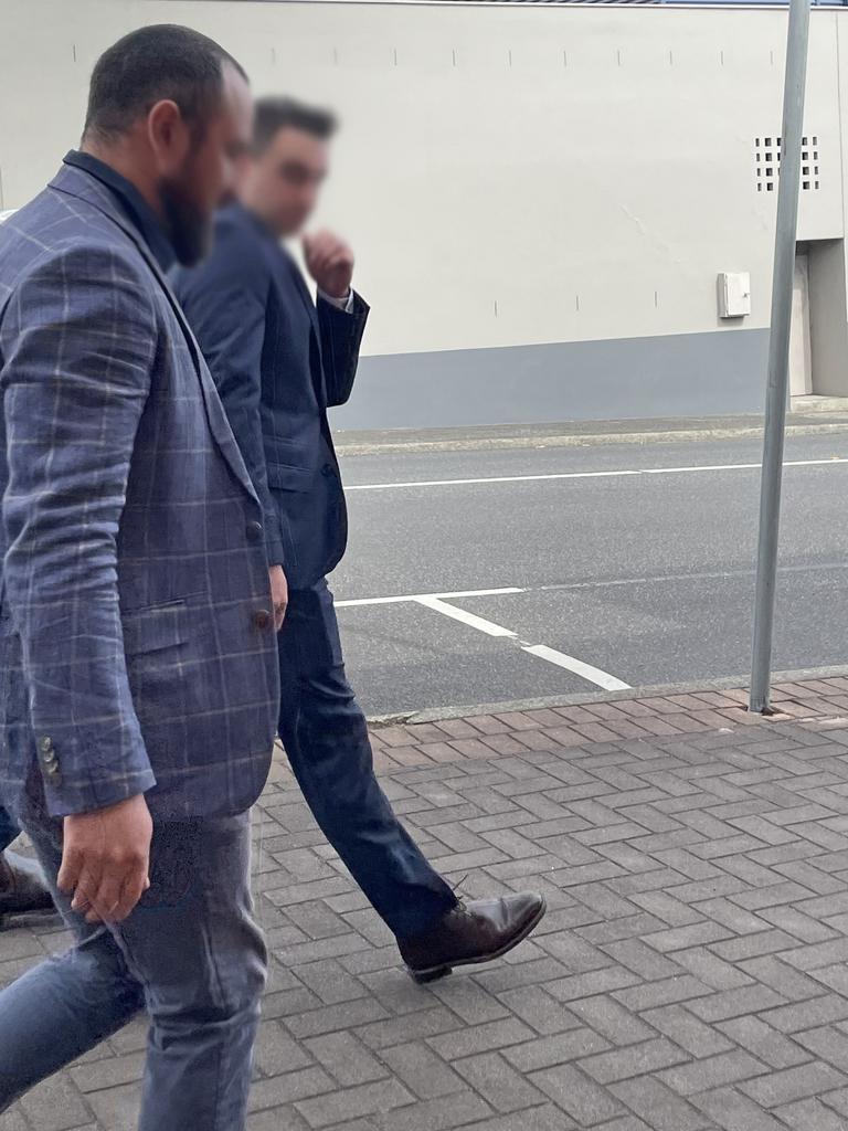 Oliver James Smith (back right) outside Devonport Magistrates Court facing assault charges.