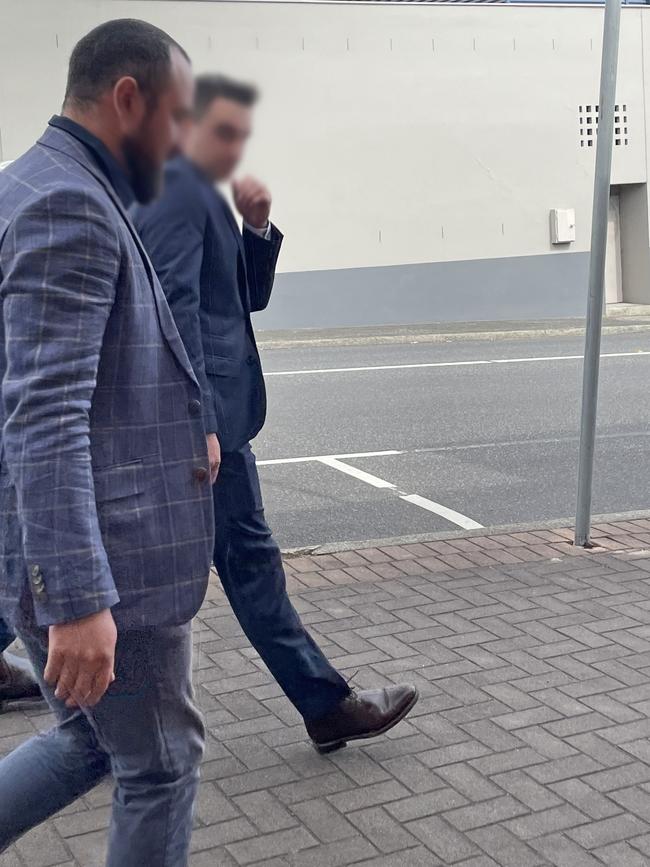 Oliver James Smith (back right) outside Devonport Magistrates Court facing assault charges.