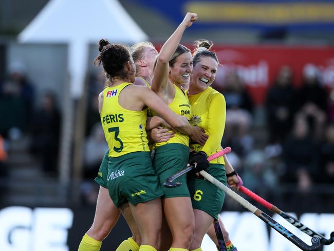 Claire Colwill is swamped by teammates after opening the Hockeyroos' scoring.