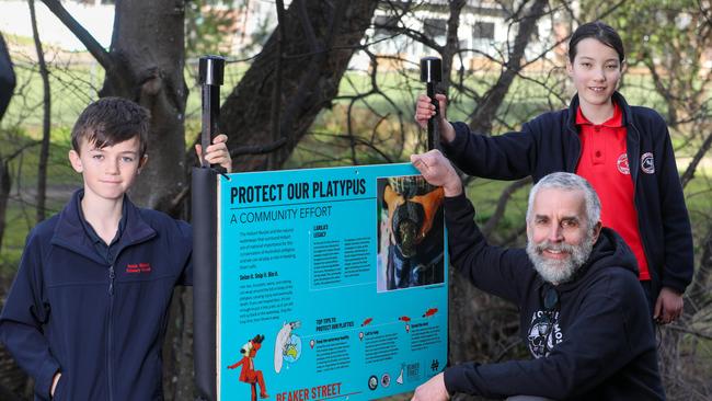 South Hobart Primary School Platypus enthusiasts Julian Warburg, 10, and Hana Morley, 11, with Pete "Platypus" Walsh at Hobart Rivulet where they have placed Platypus protection signs. Picture: Linda Higginson