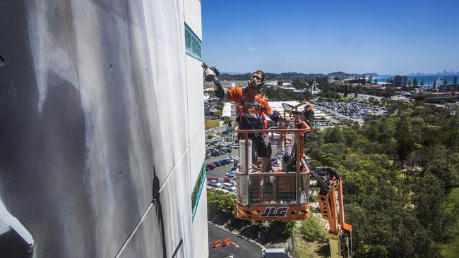 World-renowned large/scale artist Guido van Helten painting a 10-storey building at Southern Cross University Gold Coast campus. Picture: NIGEL HALLETT