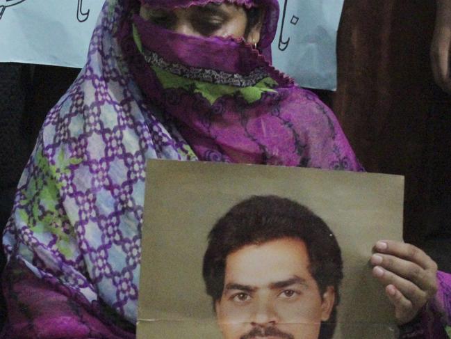 FILE - In this Sept. 18, 2016 file photo, a Pakistani woman Safia Bano displays the picture of her husband Imdad Ali, a death row prisoner, in Burewala, in central Pakistan. A Pakistani lawyer said, Monday, Oct. 31, 2016, that the Supreme Court has stayed the execution of Ali, a mentally ill prisoner whose hanging was to take place later this week. (AP Photo/Asghar Ali, File)