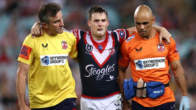 SYDNEY, AUSTRALIA - MARCH 26:  Luke Keary of the Roosters is helped off the field after a leg injury during the round three NRL match between the South Sydney Rabbitohs and the Sydney Roosters at Stadium Australia on March 26, 2021, in Sydney, Australia. (Photo by Cameron Spencer/Getty Images)