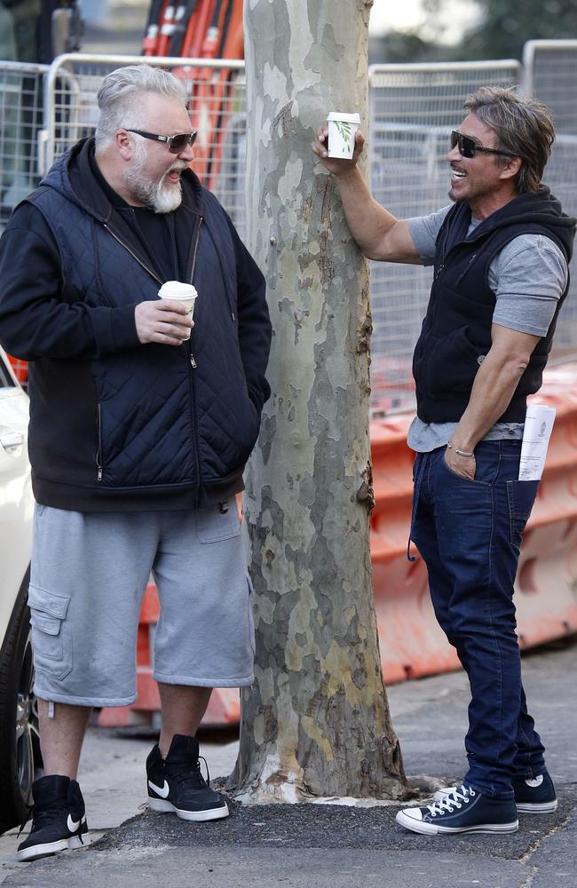 John Ibrahim and Kyle Sandilands sharing a laugh and a coffee on Bayswater Rd in Kings Cross on Tuesday as police raided the former nightclub owner’s mansion. Picture: MATRIX