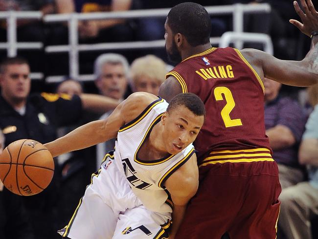 Dante Exum drives around Cleveland star Kyrie Irving.