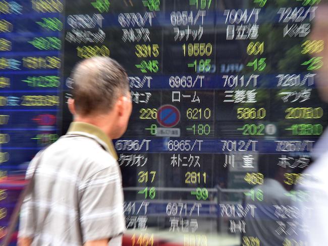 A man watches a share prices board in Tokyo on August 24, 2015. Japan's share prices dropped 623.34 points at the morning session of the Tokyo Stock Exchange, swept lower in a global equities rout as worries about China's economy deepen. AFP PHOTO / Yoshikazu TSUNO