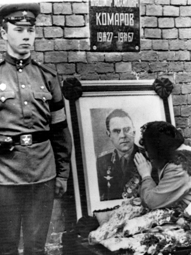 Valentina Komarov kneels to kiss photo of her dead husband, cosmonaut Vladimir Komarov.