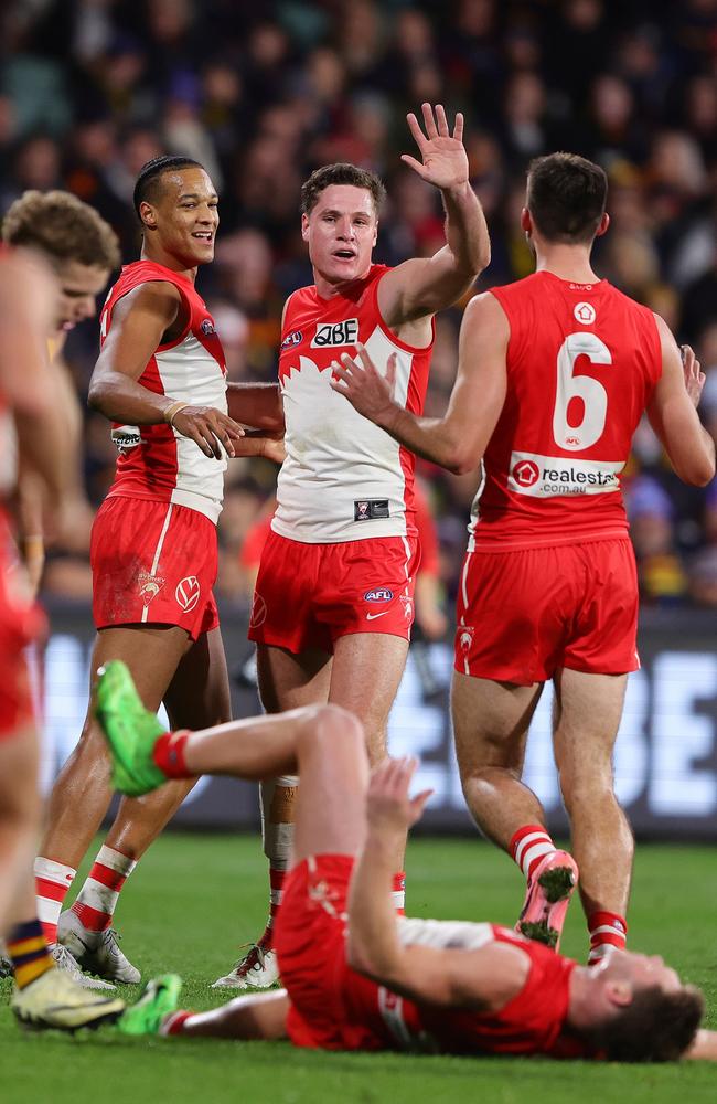 Joel Amartey of the Swans celebrates with Hayden McLean and Logan McDonald while Taylor Adams of the Swans gets pushed by Mitchell Hinge. Picture: Sarah Reed/AFL Photos via Getty Images.