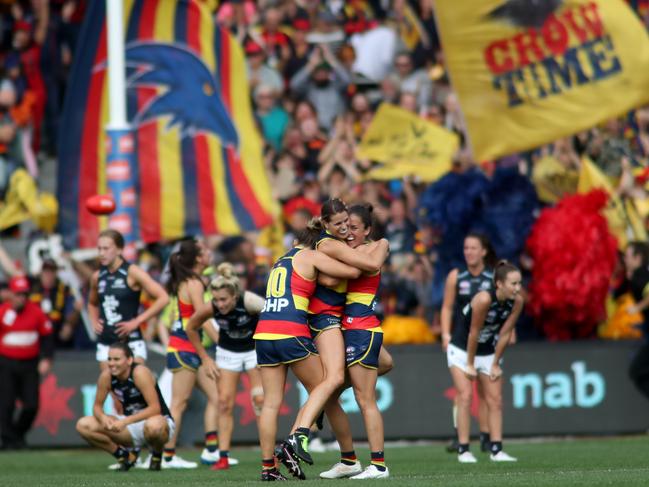 Crows players Ebony Marinoff, Chelsea Randall and Angela Foley celebrate on the final siren during the AFLW grand final match between Adelaide and Carlton in front of a record-breaking crowd at Adelaide Oval. PHOTO: AAP Image/Kelly Barnes